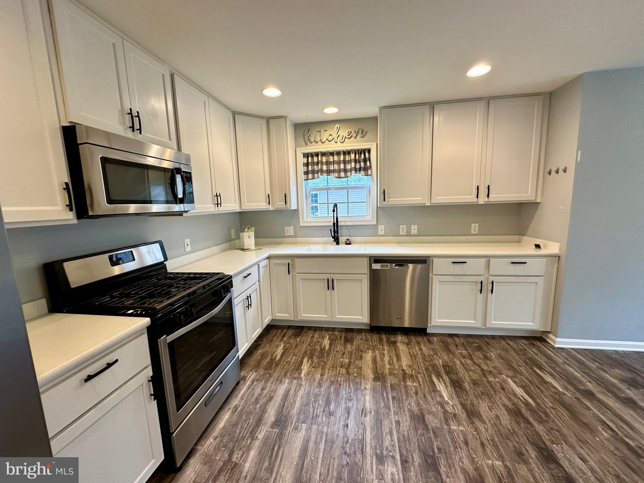 326 Sweeping Mist Circle Frederica, DE 19946 - Photo 18 of 37 a kitchen with a stove a sink and a microwave