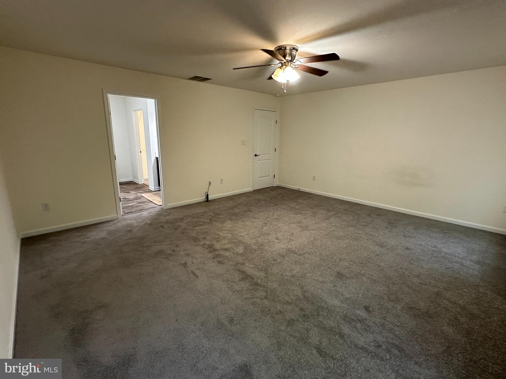 326 Sweeping Mist Circle Frederica, DE 19946 - Photo 20 of 37 an empty room with a chandelier fan and windows
