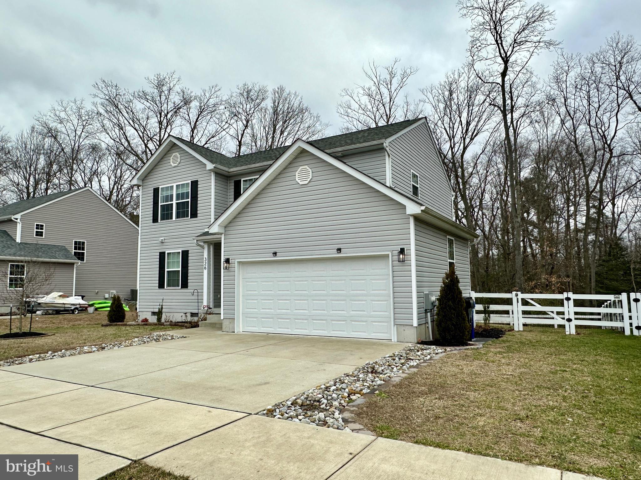 326 Sweeping Mist Circle Frederica, DE 19946 - Photo 2 of 37 a front view of a house with garden