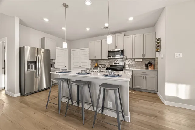 a kitchen with stainless steel appliances granite countertop a white cabinets and wooden floor