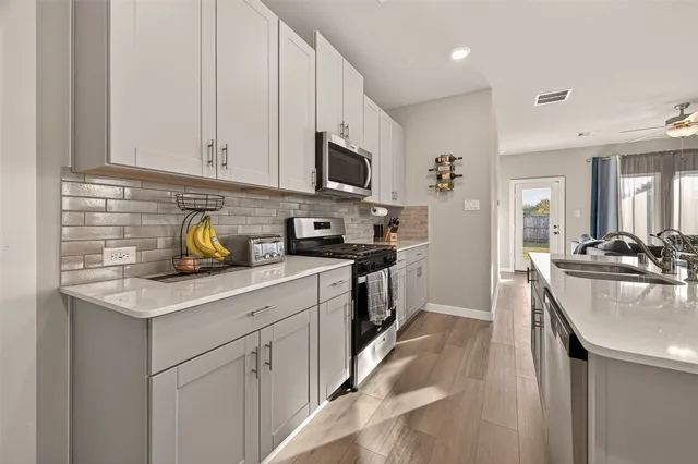 a kitchen with stainless steel appliances a refrigerator a stove and cabinets