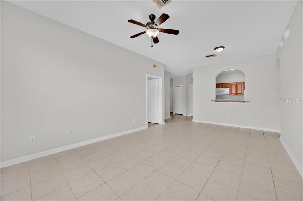 13524 Turtle Marsh Loop, Unit 621 Orlando, FL 32837 - Photo 12 of 26 an empty room with chandelier fan and windows