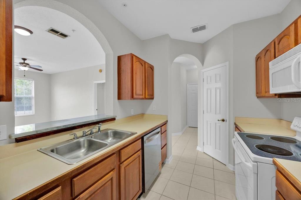 13524 Turtle Marsh Loop, Unit 621 Orlando, FL 32837 - Photo 13 of 26 a kitchen that has a sink and a stove