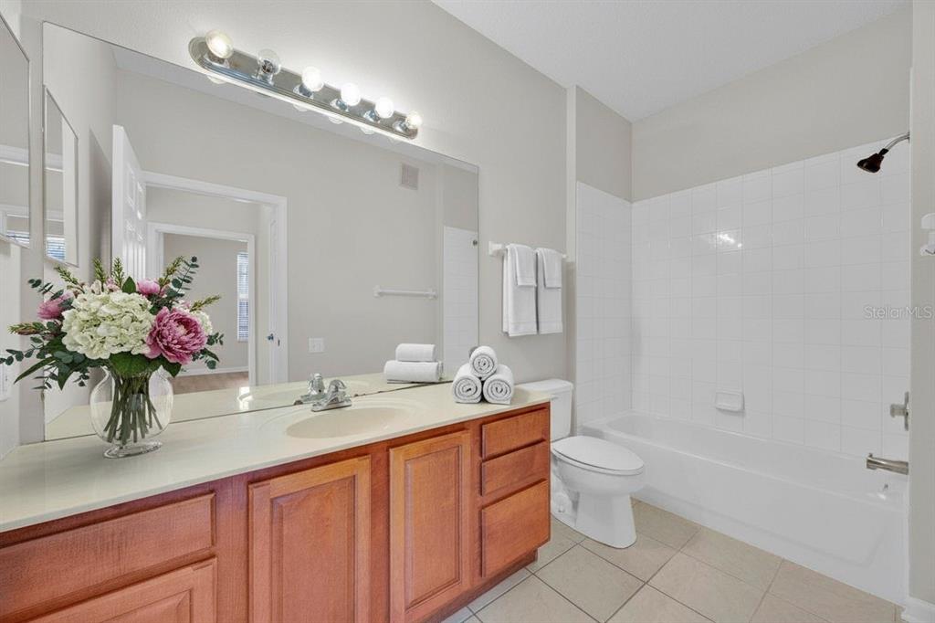13524 Turtle Marsh Loop, Unit 621 Orlando, FL 32837 - Photo 9 of 26 a bathroom with a granite countertop sink a toilet and a mirror