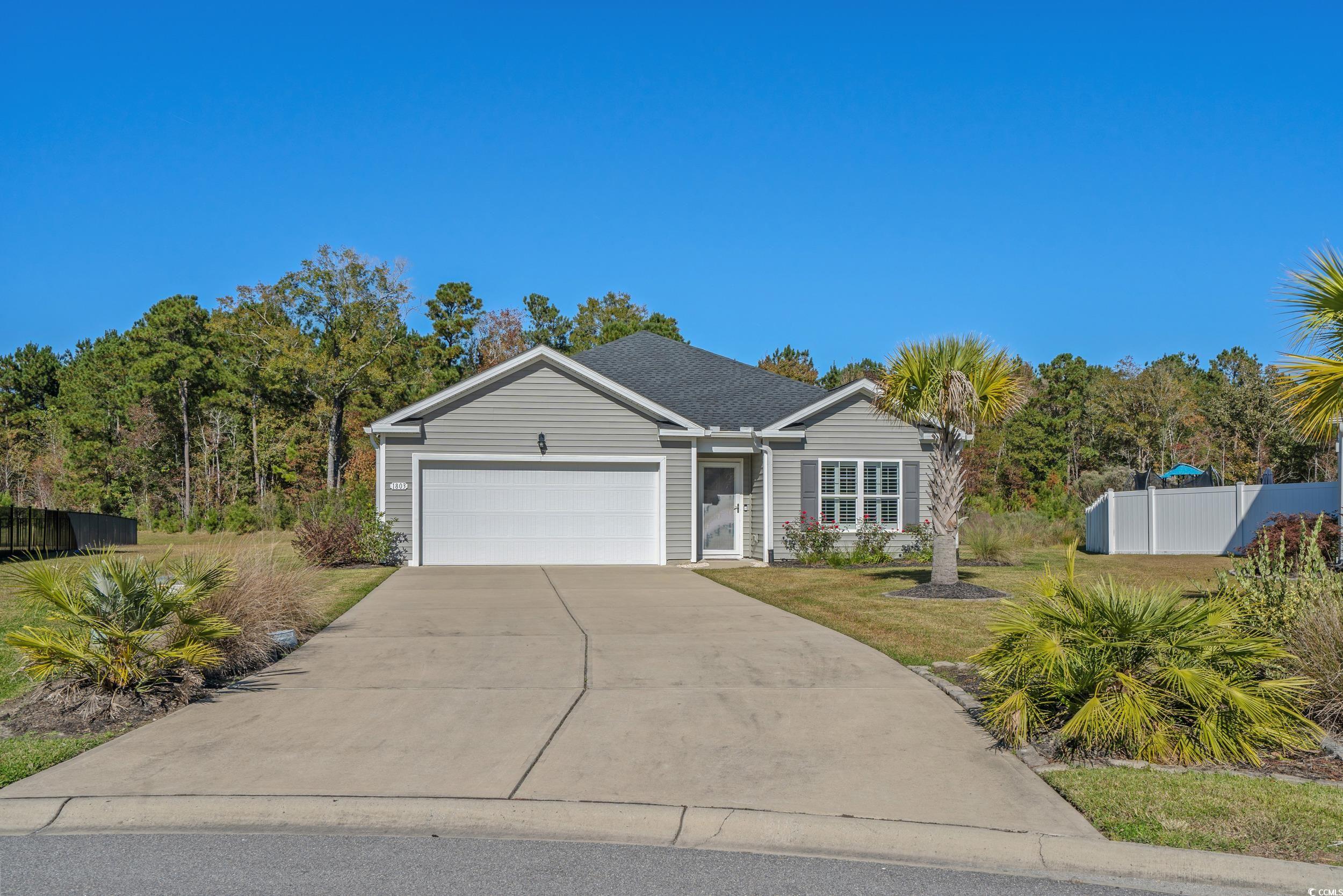 Ranch-style home featuring an attached garage and concrete driveway