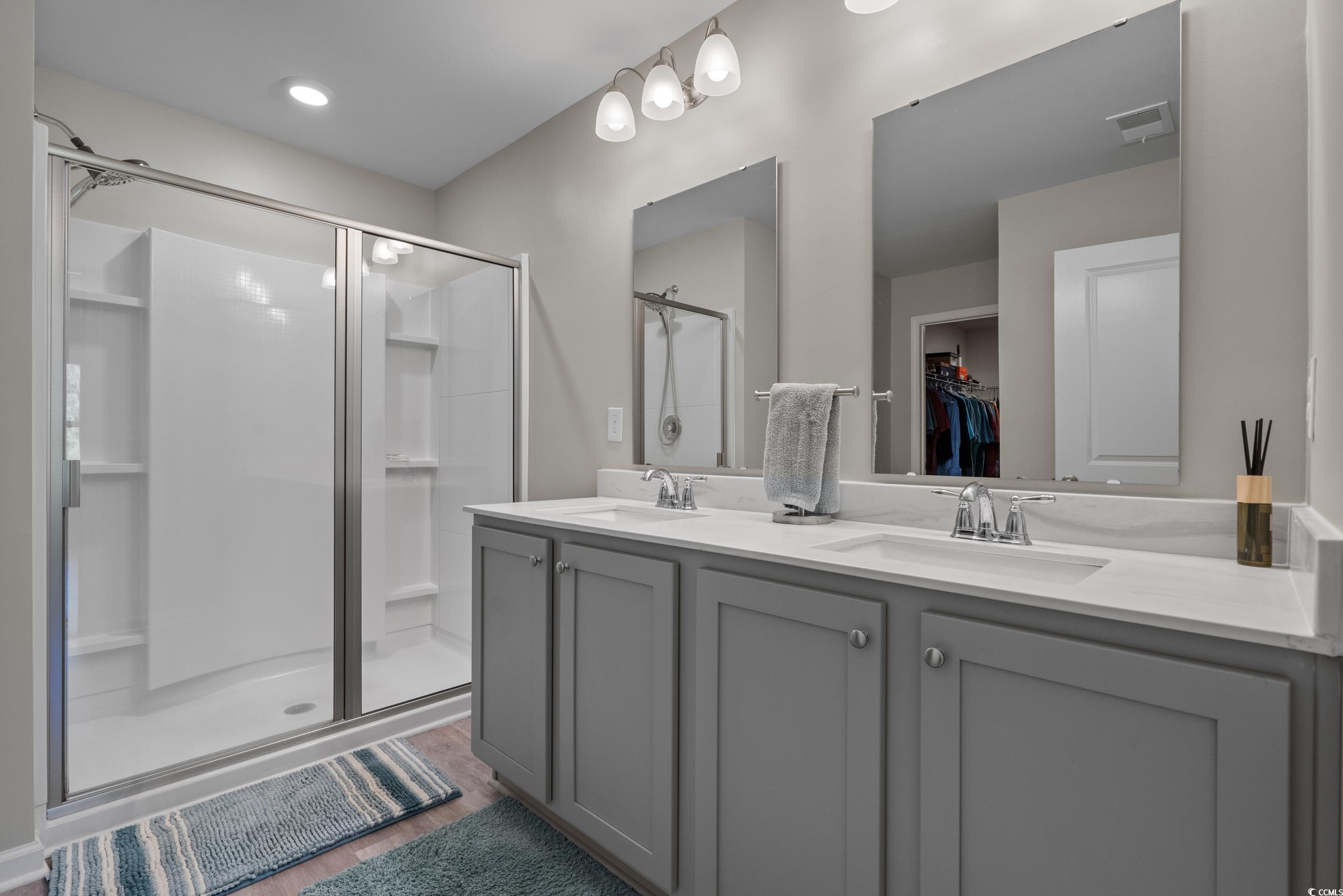 1803 Promise Pl. Myrtle Beach, SC 29588 - Photo 25 of 40 Bathroom with a spacious closet, double vanity, a stall shower, and dark wood-style floors