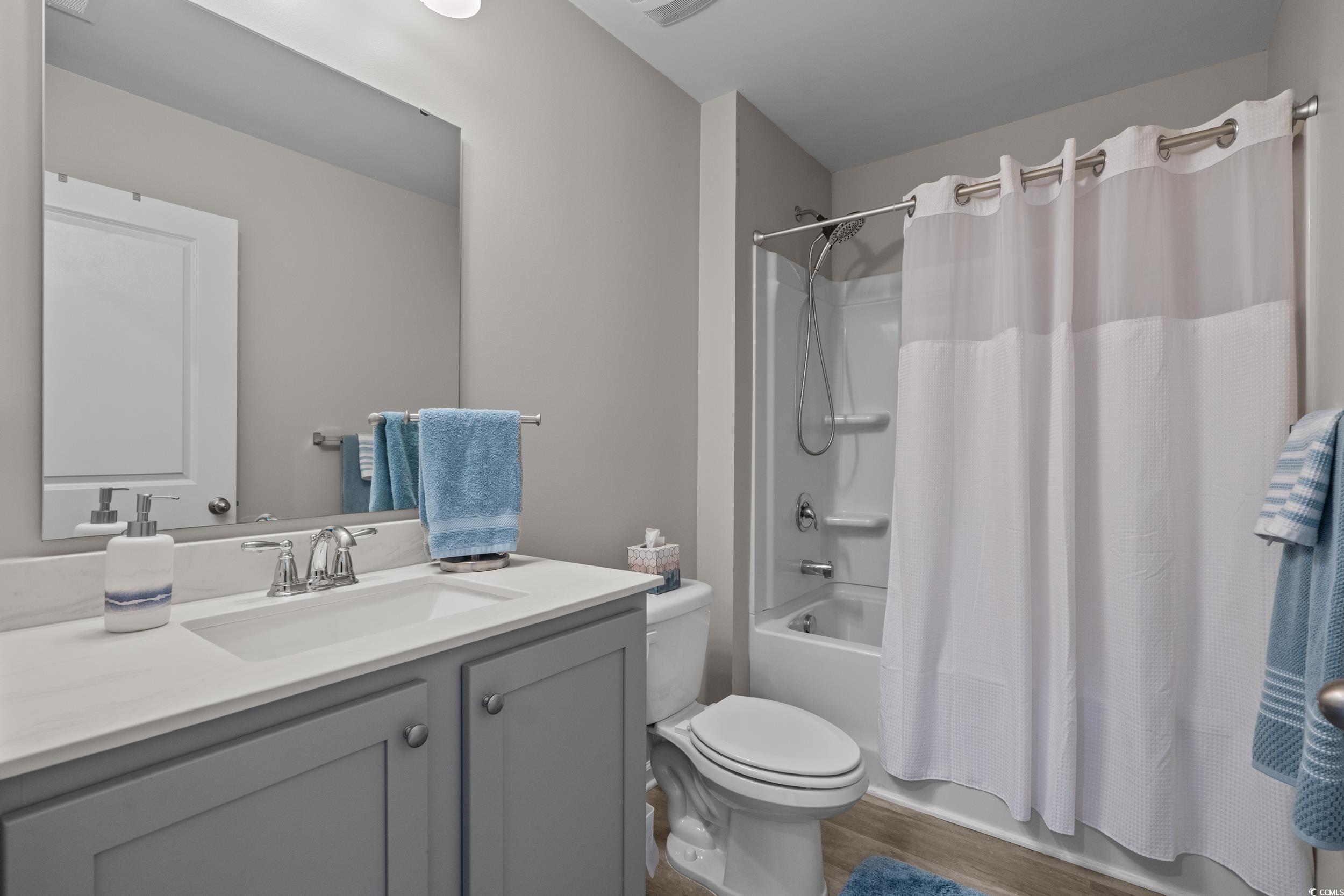 1803 Promise Pl. Myrtle Beach, SC 29588 - Photo 29 of 40 Bathroom featuring shower / tub combo with curtain, vanity, and dark wood finished floors