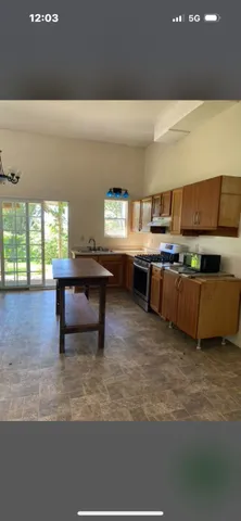 a living room with stainless steel appliances kitchen island furniture and a kitchen view
