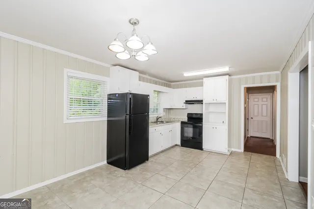 a kitchen with a refrigerator and a stove top oven