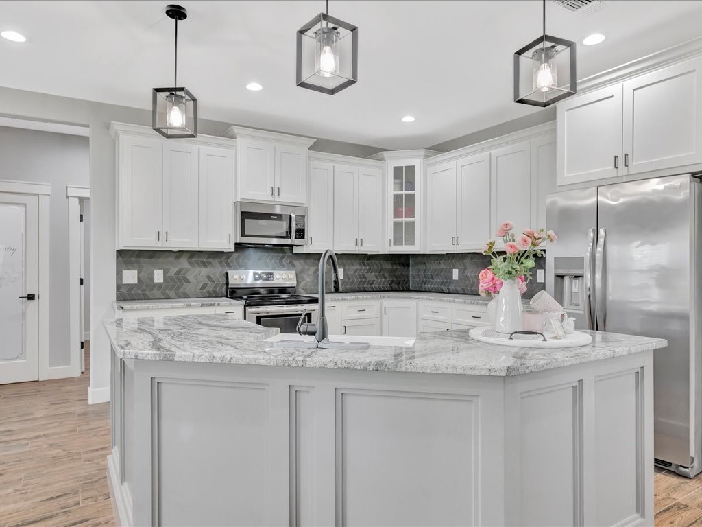 1105 C C Road Diboll, TX 75941 - Photo 1 of 40 a kitchen with kitchen island granite countertop stainless steel appliances a stove center island cabinets and wooden floor