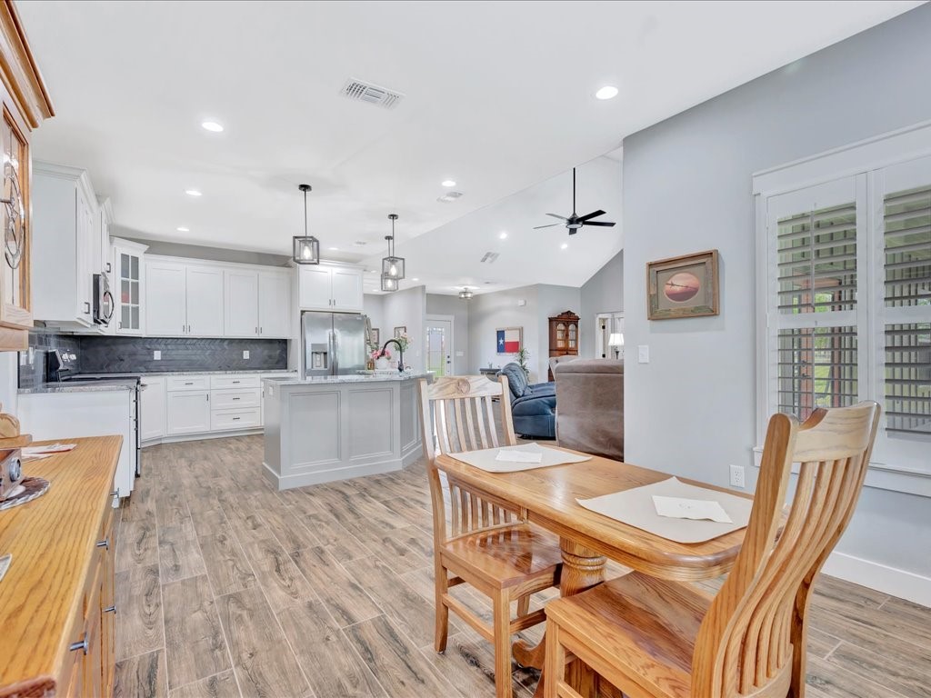 1105 C C Road Diboll, TX 75941 - Photo 19 of 40 a kitchen with stainless steel appliances granite countertop a refrigerator a stove top oven and white cabinets with wooden floor