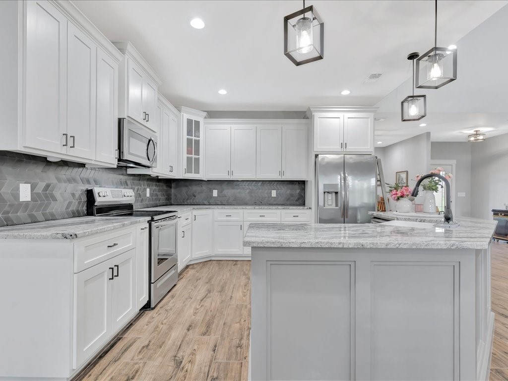1105 C C Road Diboll, TX 75941 - Photo 20 of 40 a kitchen with stainless steel appliances granite countertop a sink a stove and cabinets