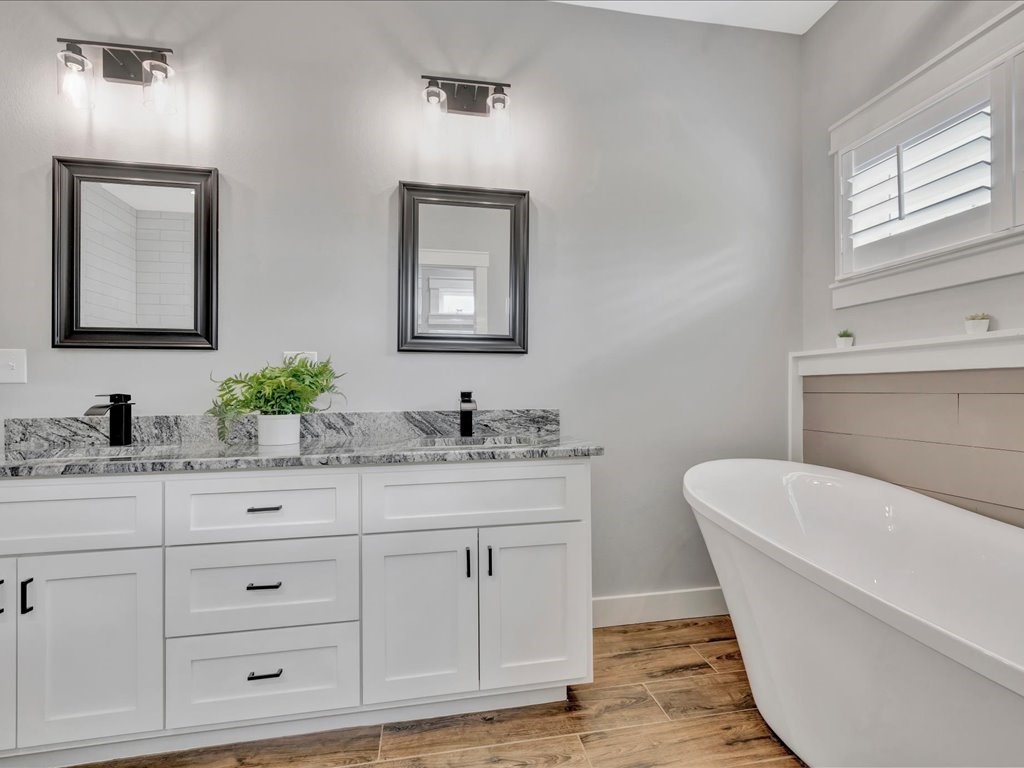 1105 C C Road Diboll, TX 75941 - Photo 27 of 40 a bathroom with a double vanity sink a mirror and a bathtub