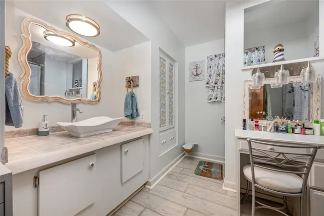 a en suite bathroom with a granite countertop sink and a mirror