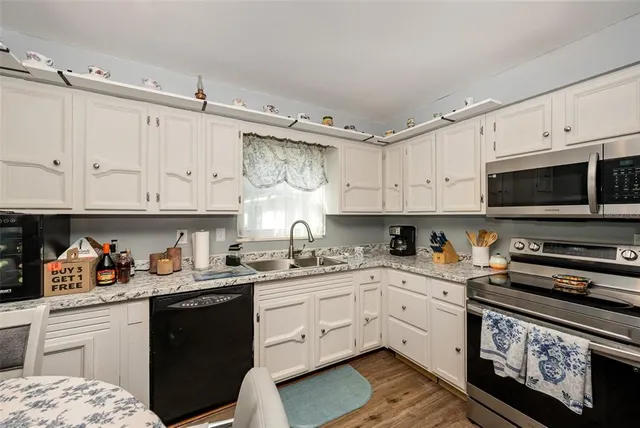a kitchen with cabinets appliances a sink and a counter top space