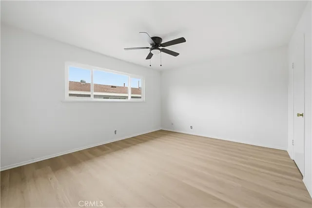 an empty room with windows and fan