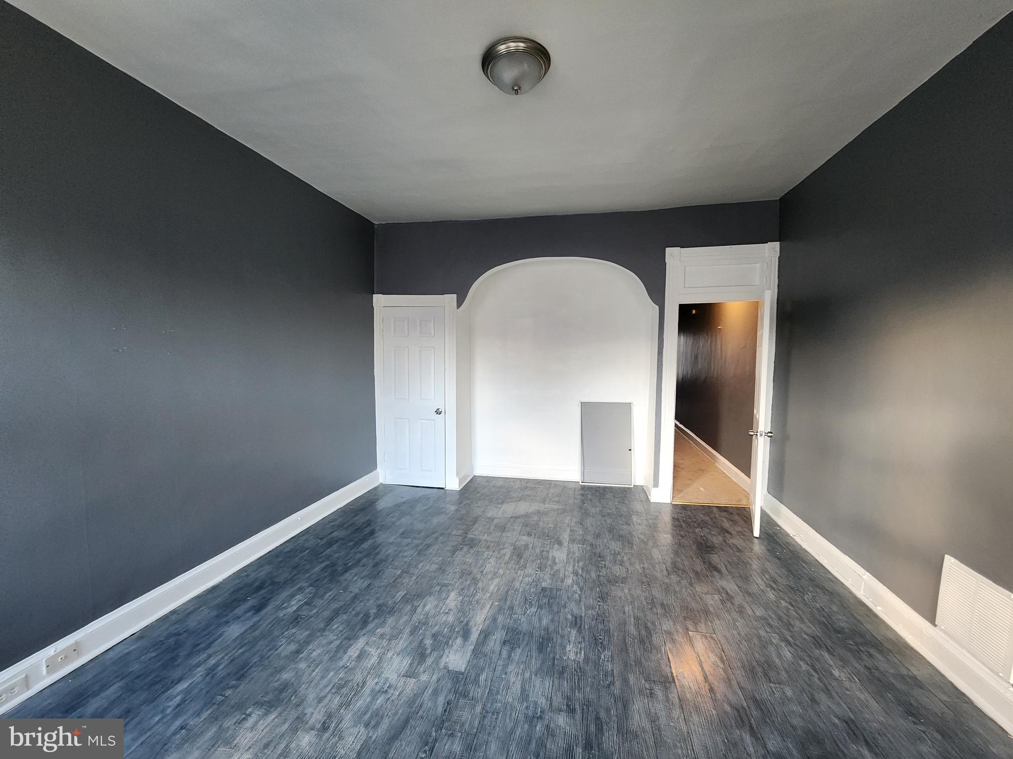 810 Appleton Street Baltimore, MD 21217 - Photo 27 of 27 an empty room with wooden floor and windows
