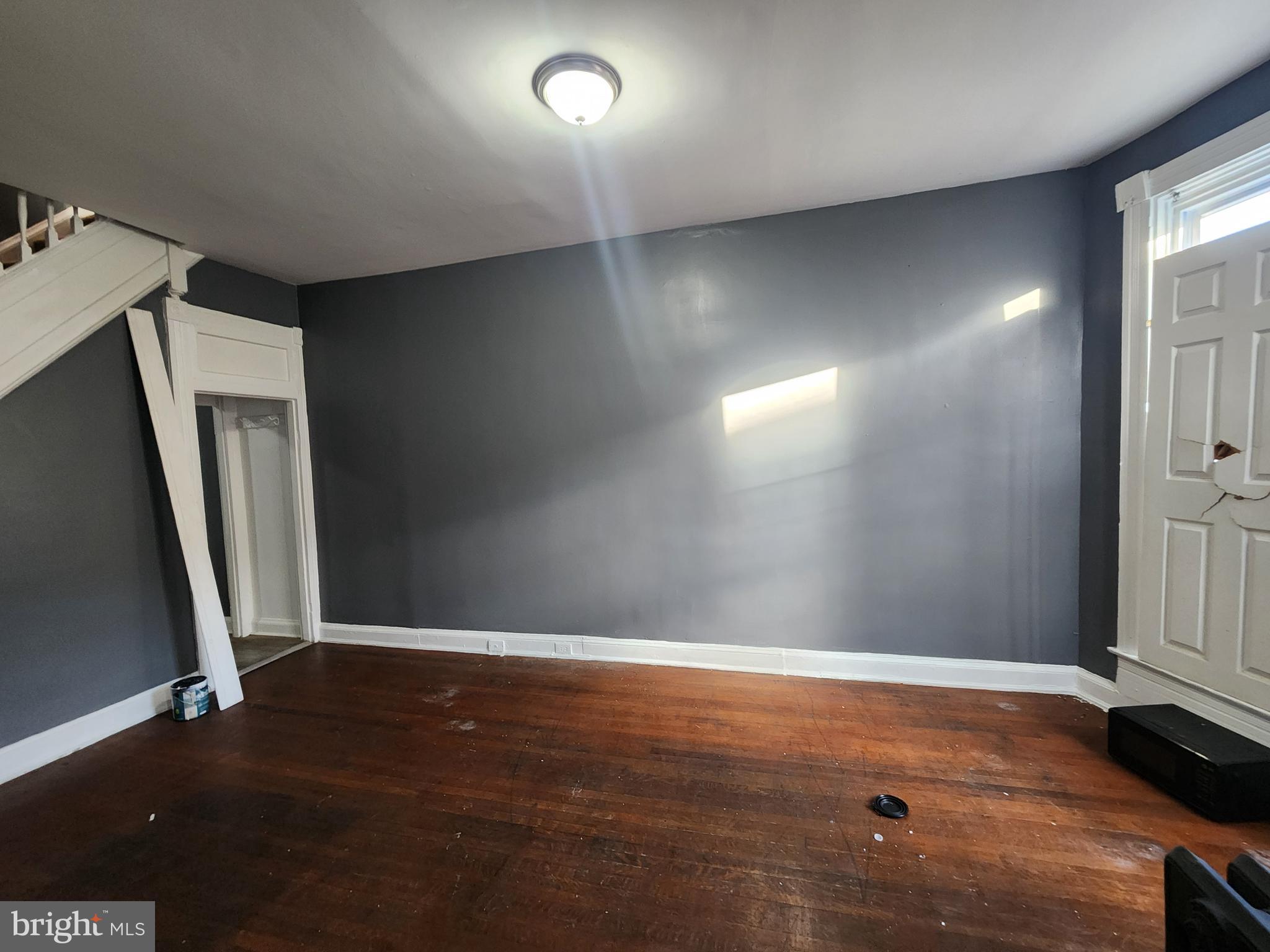 810 Appleton Street Baltimore, MD 21217 - Photo 4 of 27 an empty room with wooden floor and a window