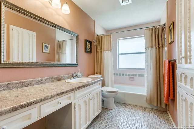 a bathroom with a granite countertop sink and a bathtub