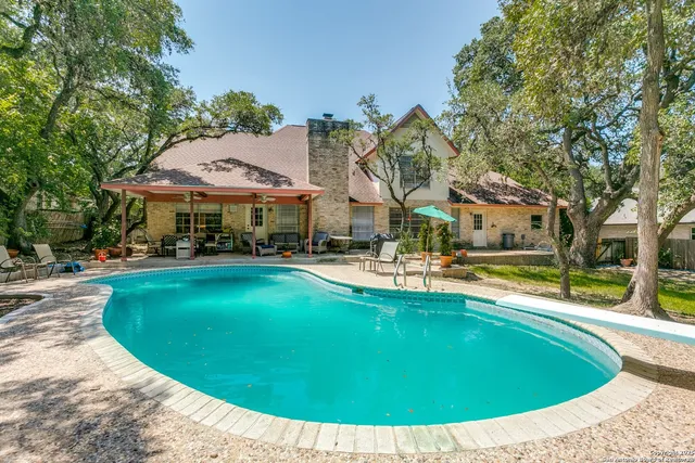 a view of a swimming pool with outdoor seating and plants