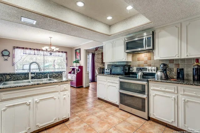 a kitchen with stainless steel appliances granite countertop a stove and cabinets