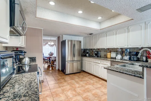 a kitchen with stainless steel appliances granite countertop a refrigerator and a stove top oven
