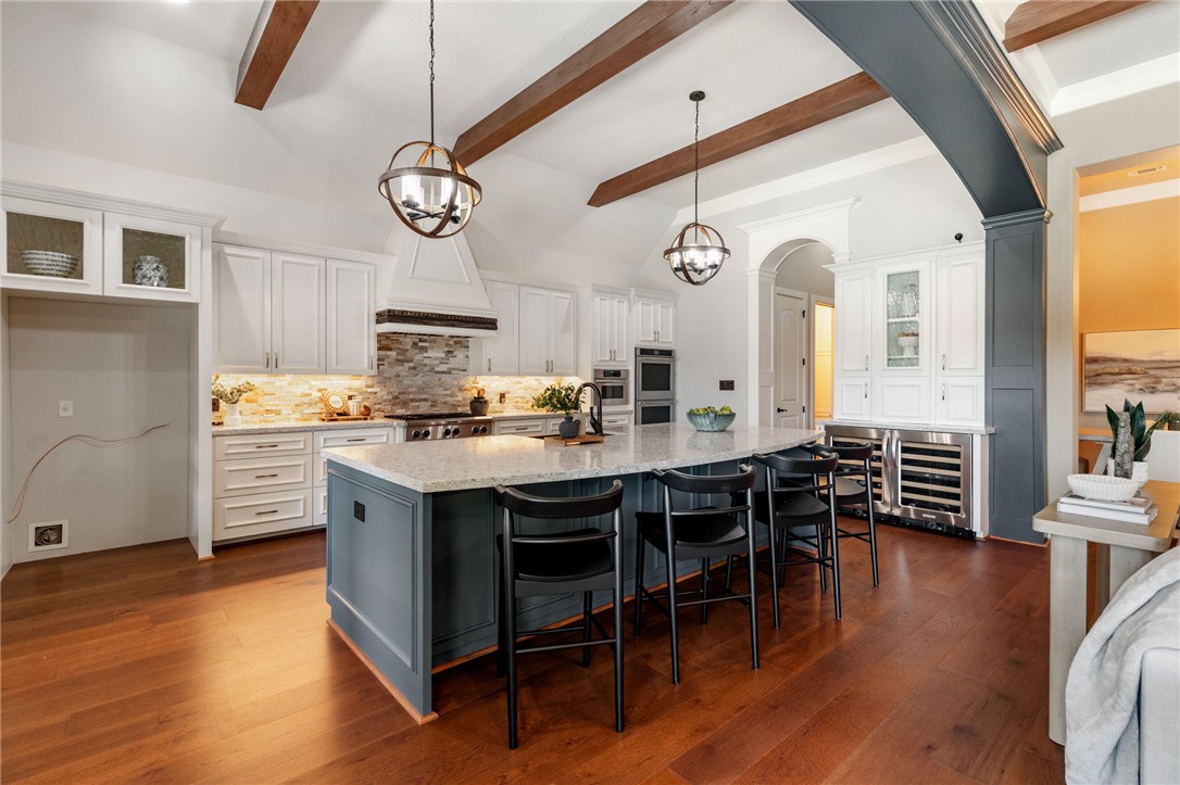 2833 Persimmon Ridge Court Bryan, TX 77807 - Photo 27 of 50 a kitchen with stainless steel appliances granite countertop a stove a sink dishwasher and a dining table with wooden floor