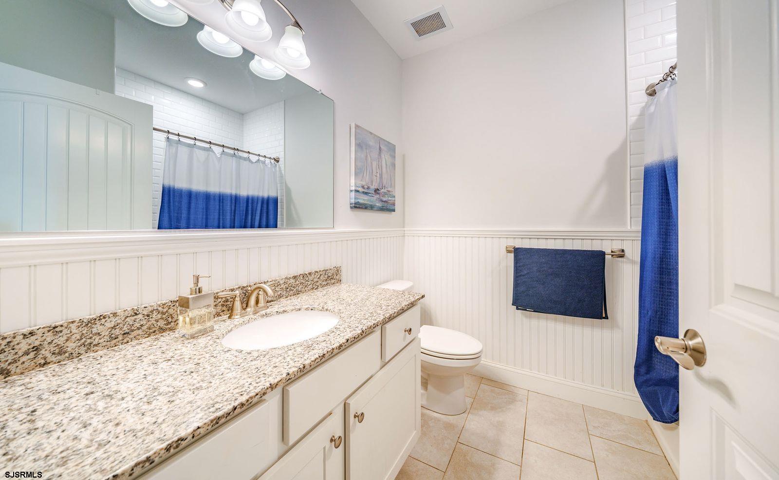 901 Wesley Avenue, Unit B Ocean City, NJ 08226 - Photo 19 of 33 a bathroom with a granite countertop sink a toilet and a mirror