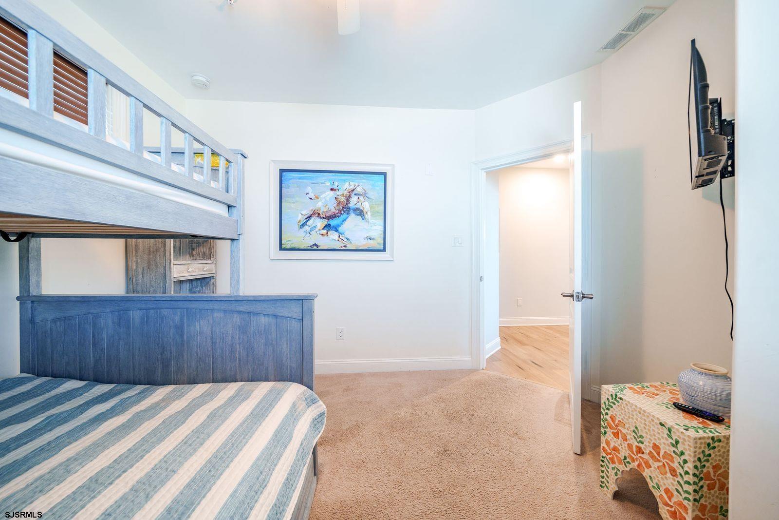 901 Wesley Avenue, Unit B Ocean City, NJ 08226 - Photo 20 of 33 a bedroom with a bed and wooden floor