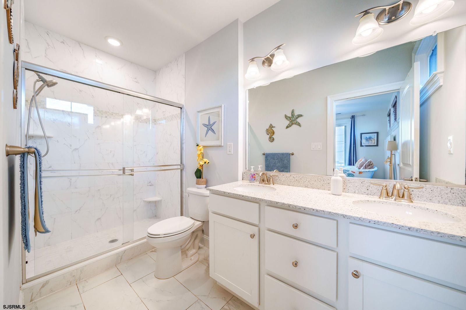 901 Wesley Avenue, Unit B Ocean City, NJ 08226 - Photo 24 of 33 a spacious bathroom with a double vanity sink toilet mirror and shower