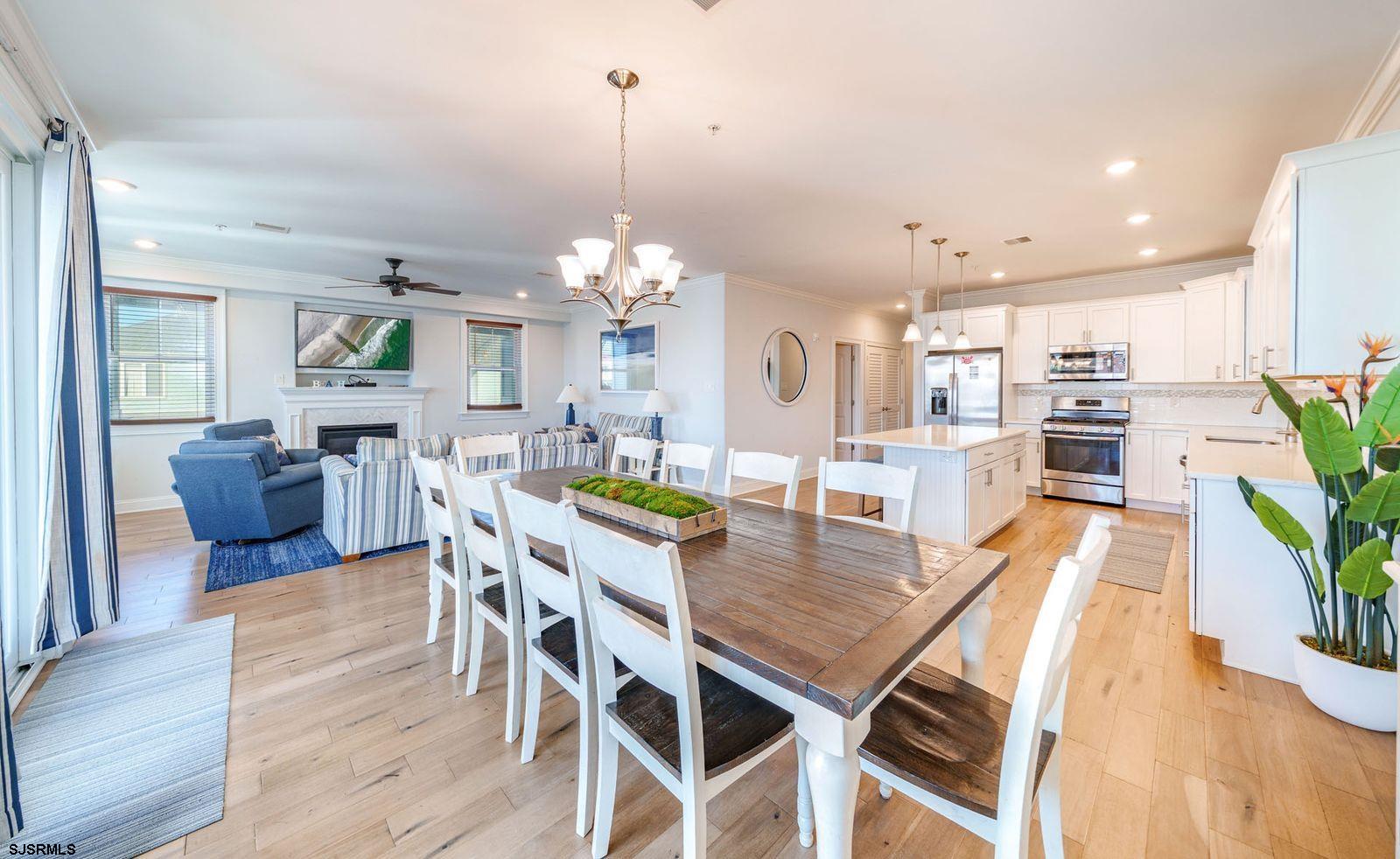 901 Wesley Avenue, Unit B Ocean City, NJ 08226 - Photo 8 of 33 a dining room with wooden floor a chandelier a wooden table and chairs