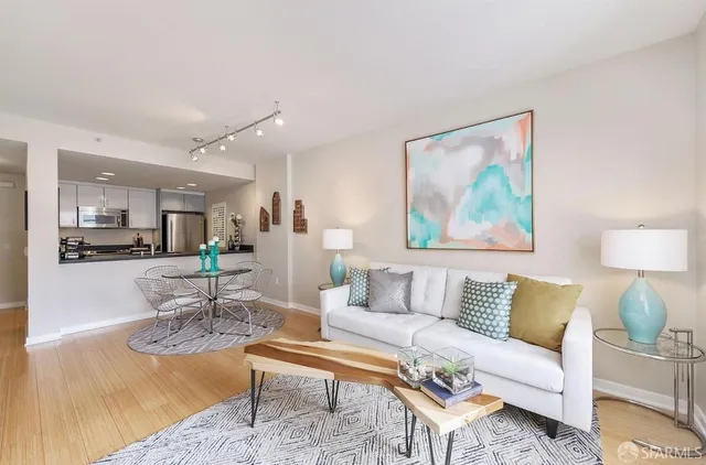 a living room with furniture and a dining table with kitchen view