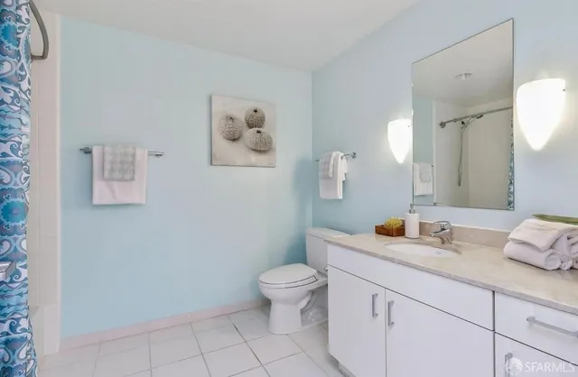 a bathroom with a granite countertop sink a toilet and a mirror