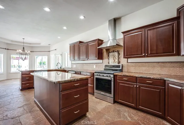 a kitchen with stainless steel appliances granite countertop wooden cabinets and a stove top oven