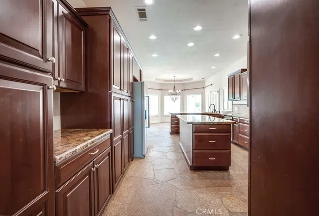a kitchen with stainless steel appliances granite countertop a refrigerator and a sink