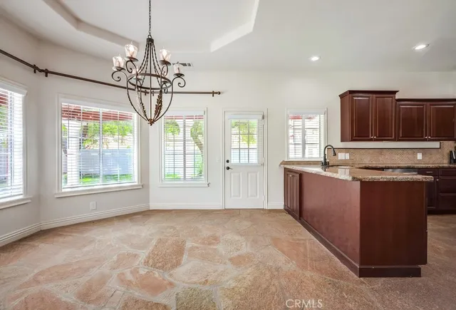 a large kitchen with kitchen island granite countertop a stove and a wooden floors