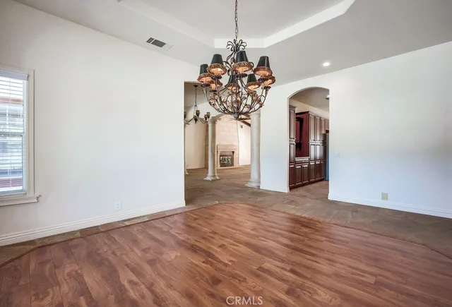 a view of a room with wooden floor and chandelier
