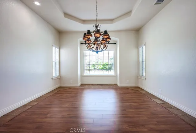 a very nice looking room with wooden floors windows and chandelier