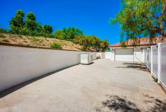 a backyard of a house with a garden and outdoor seating