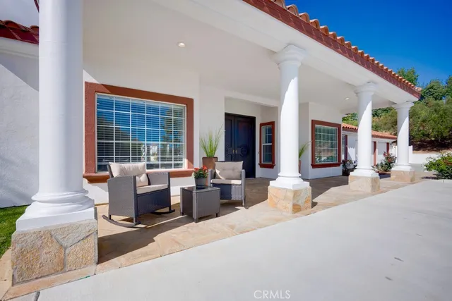 a living room with furniture a large window and a chandelier