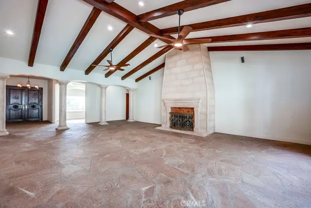 a view of an empty room with a fireplace and a window