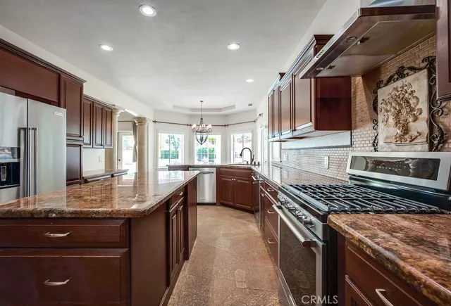 a kitchen with kitchen island granite countertop a sink stove and refrigerator