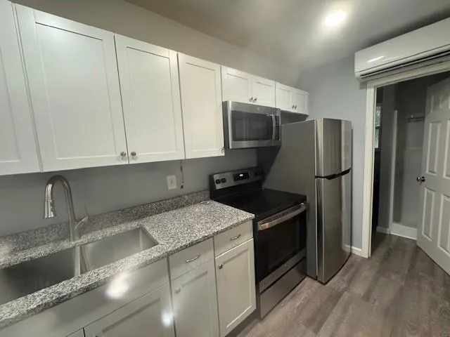 a kitchen with granite countertop a refrigerator and a sink
