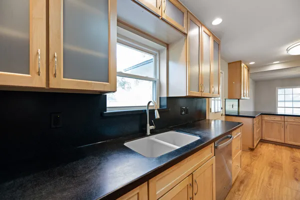 a kitchen with kitchen island granite countertop a sink window and cabinets