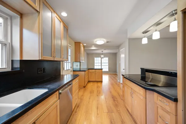 a large kitchen with stainless steel appliances a large counter top a stove a chimney a sink and a large window