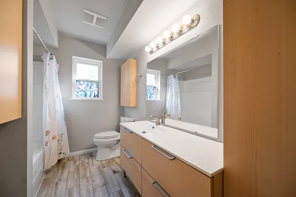a spacious bathroom with a double vanity sink a toilet and a mirror