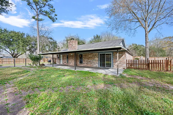 a view of a house with a backyard and a tree