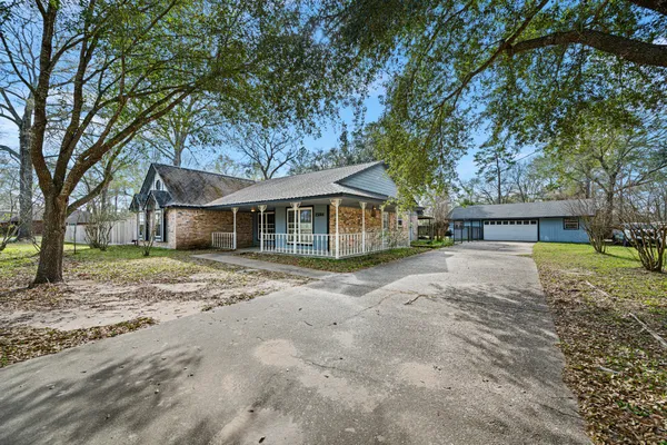 a view of a house with a yard and large tree