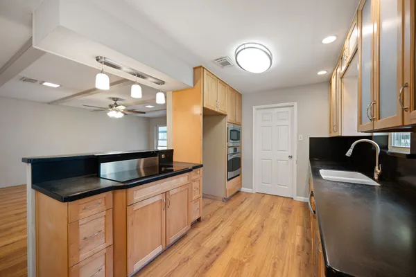 a kitchen with granite countertop a sink and refrigerator
