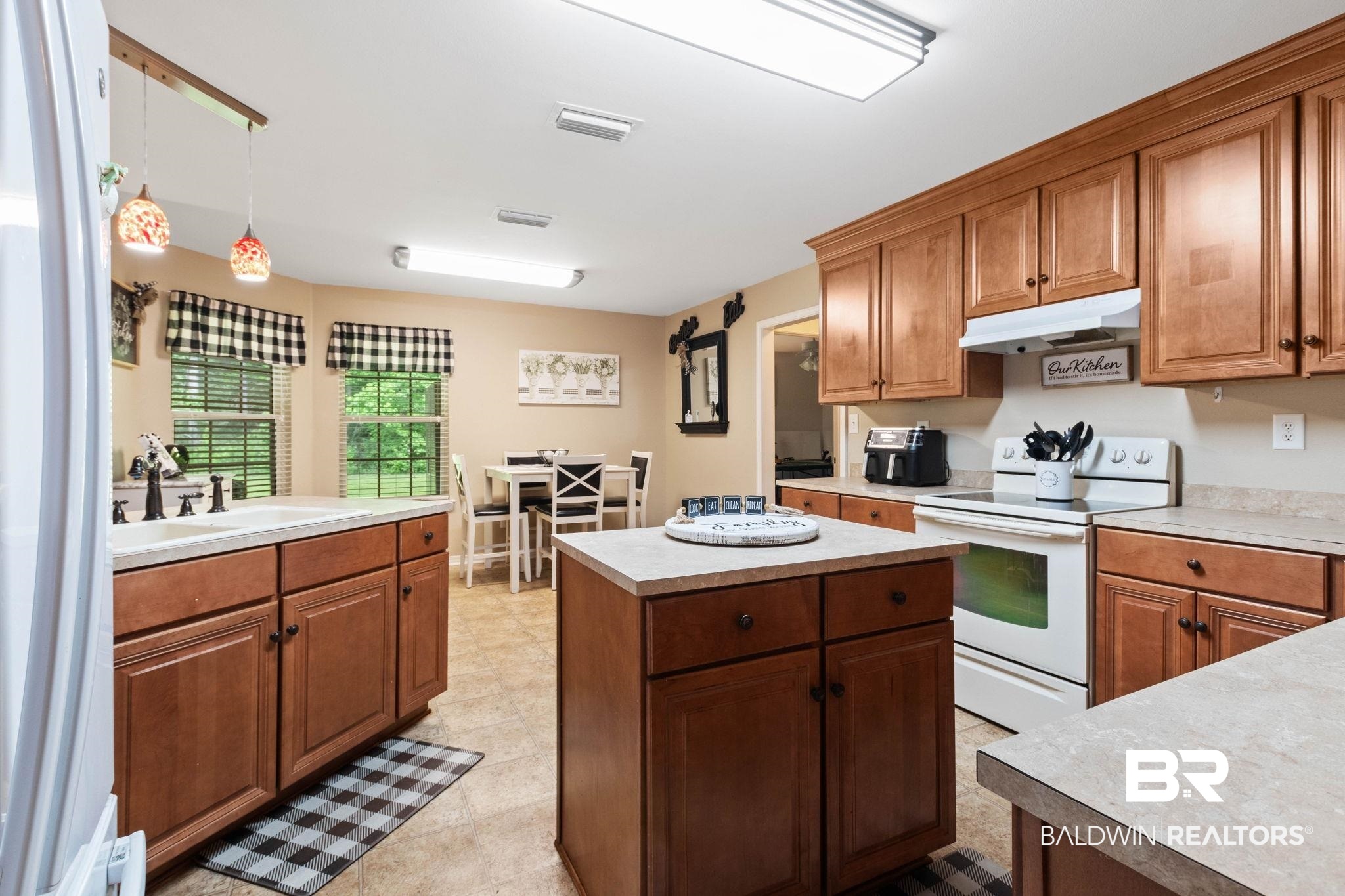 16151 Tolbert Road Bay Minette, AL 36507 - Photo 17 of 74 Kitchen featuring wood cabinetry, white appliances, a center island with storage, double basin sink, and tile flooring
